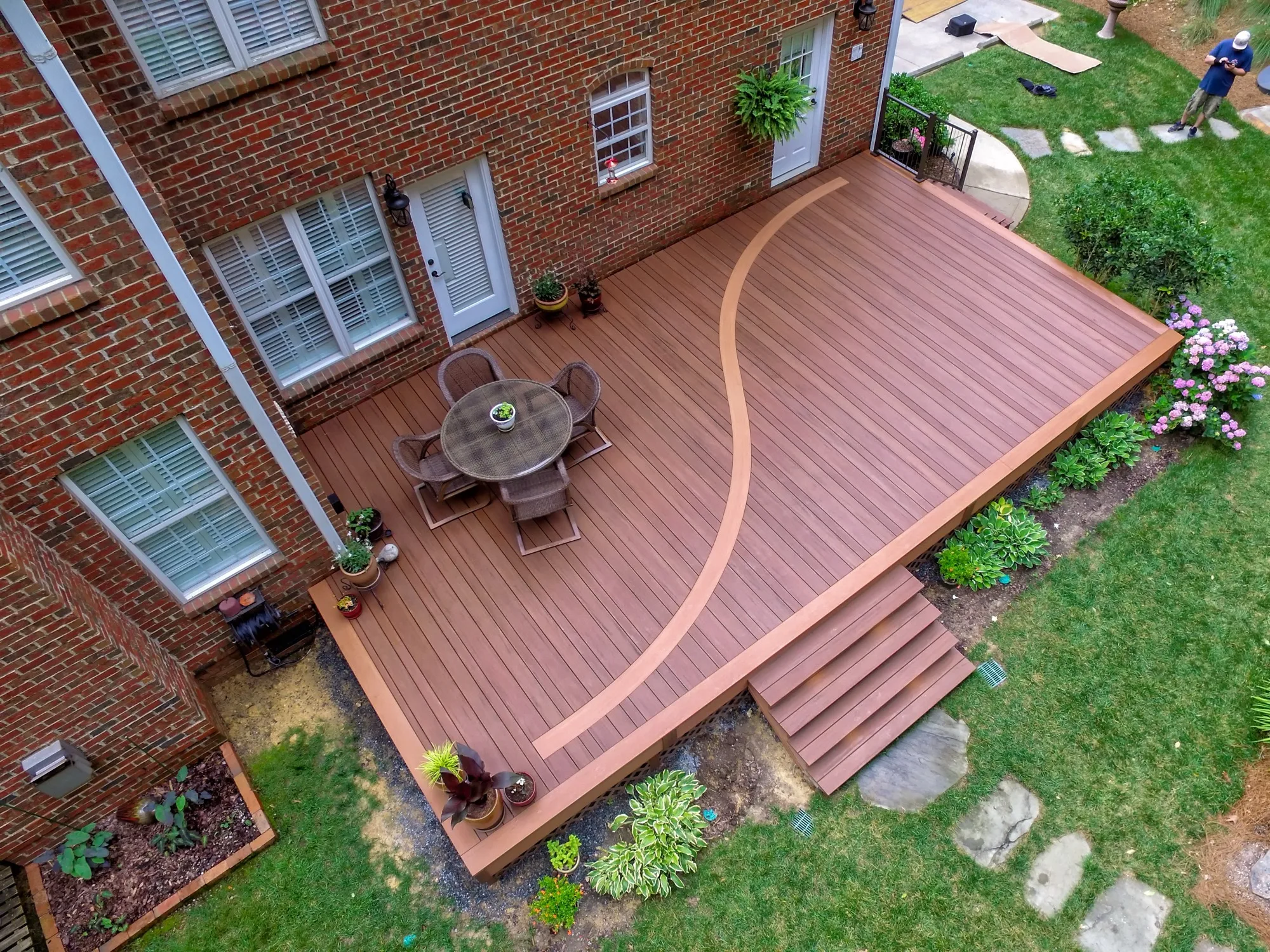 Aerial view of a curved two-tone composite deck with a patio dining set built by Open Air Construction in Charlotte, NC